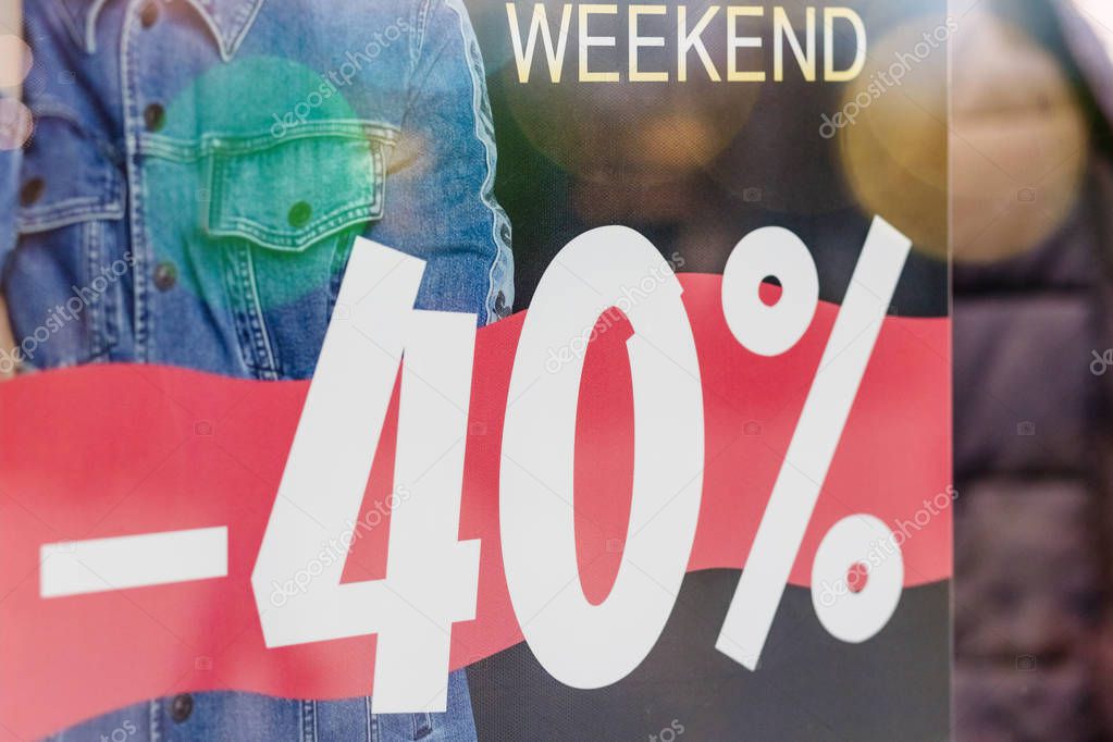 Vetrina di negozio con vetrofania promozionale per saldi in primo piano
